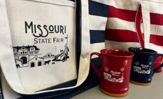 Missouri State Fair souvenir canvas totes and mugs on a table