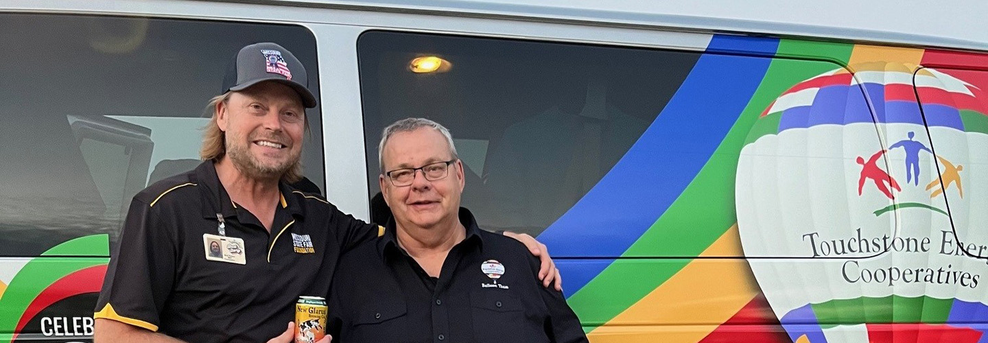 A Foundation member and a business partners outside the partner's van at an event for the foundation