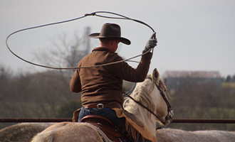 A young man roping on a horse