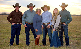 A group of people standing in front of a sunset