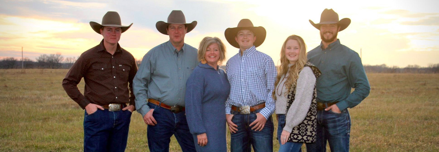 A group of people standing in front of a sunset