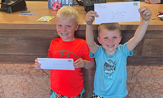 Two young read to win competitors showing off their entries